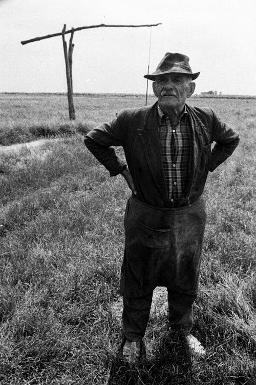 Monochrome Shot of an Elderly Man Standing on Grass Field