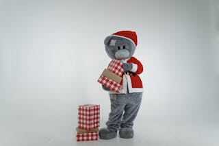 A Teddy Bear Mascot in Santa Claus Costume Holding Christmas Presents