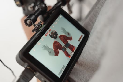 Behind the scenes shot of Santa Claus actor being recorded during a photoshoot.