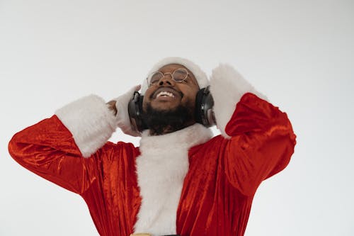Man in Santa Claus Costume Listening to Music