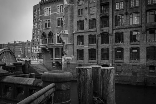 Free Grayscale image captures historic brick architecture by a canal. Stock Photo