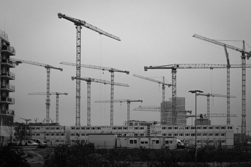 Free Black and white image of a construction site with multiple tower cranes. Stock Photo
