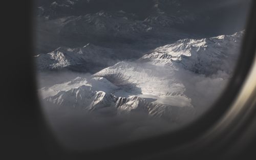 Free Breathtaking aerial view of snow-capped Swiss Alps through an airplane window. Stock Photo