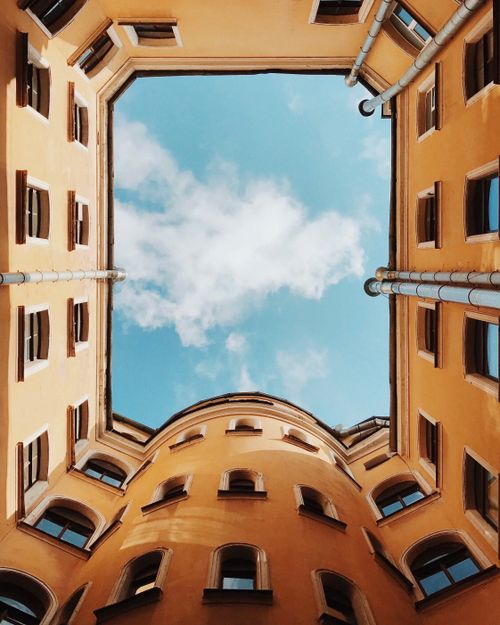 Free Looking up in a courtyard reveals a sunny sky and historic architecture in Saint Petersburg. Stock Photo