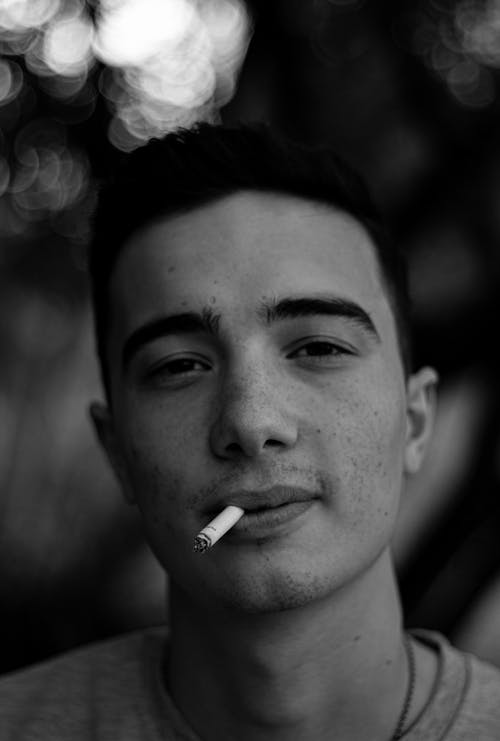 Black and White Photo of a Man Smoking Cigarette 