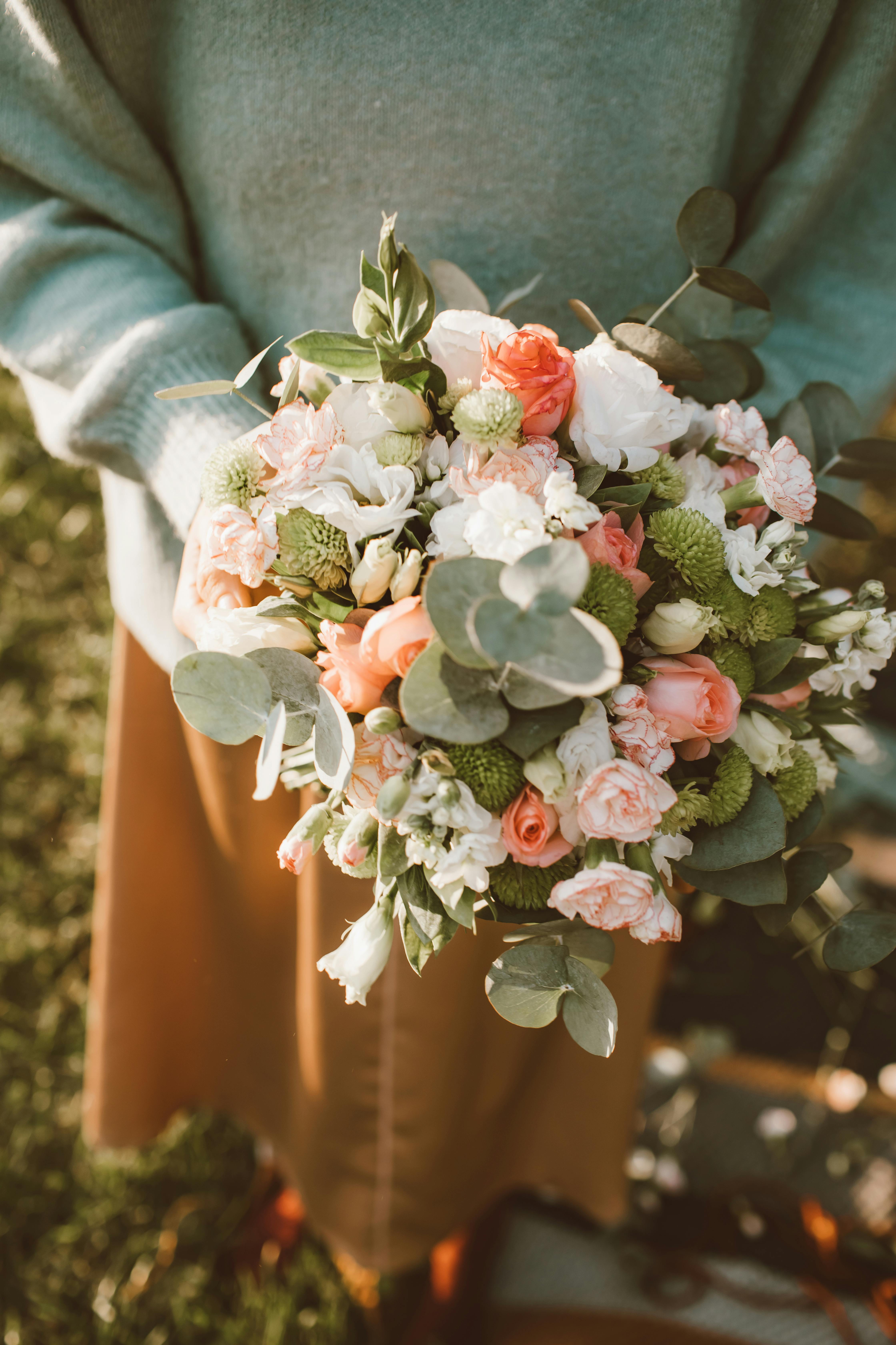 A beautiful floral bouquet held outdoors, enveloped in warm sunlight.