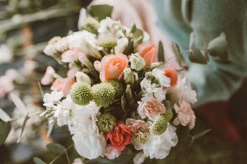 Free A beautiful close-up of a floral arrangement featuring roses and seasonal greenery. Stock Photo