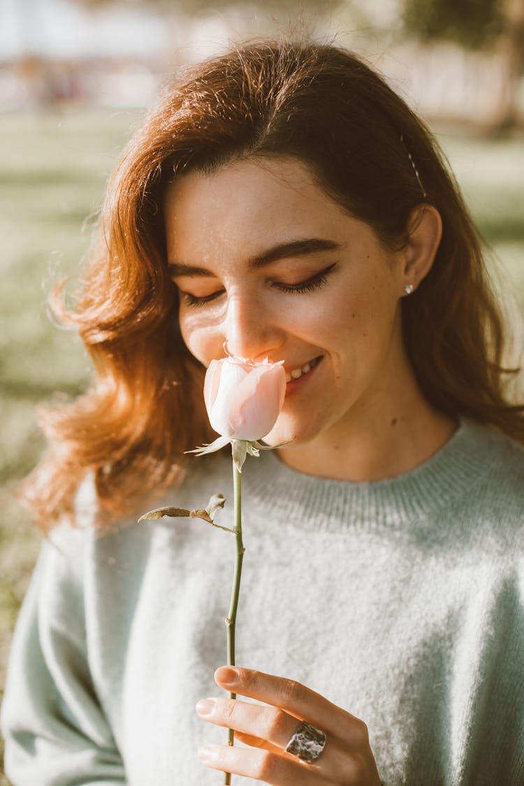 Woman Smelling A Rose