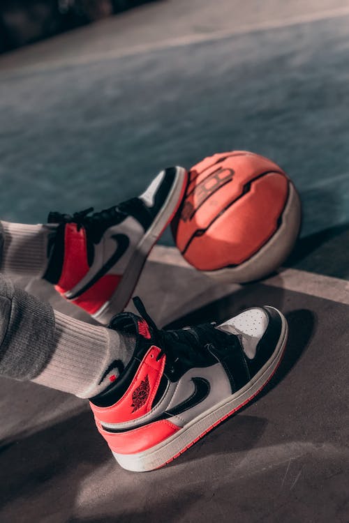 Person Wearing Sneakers Stepping on a Basketball Ball · Free Stock Photo