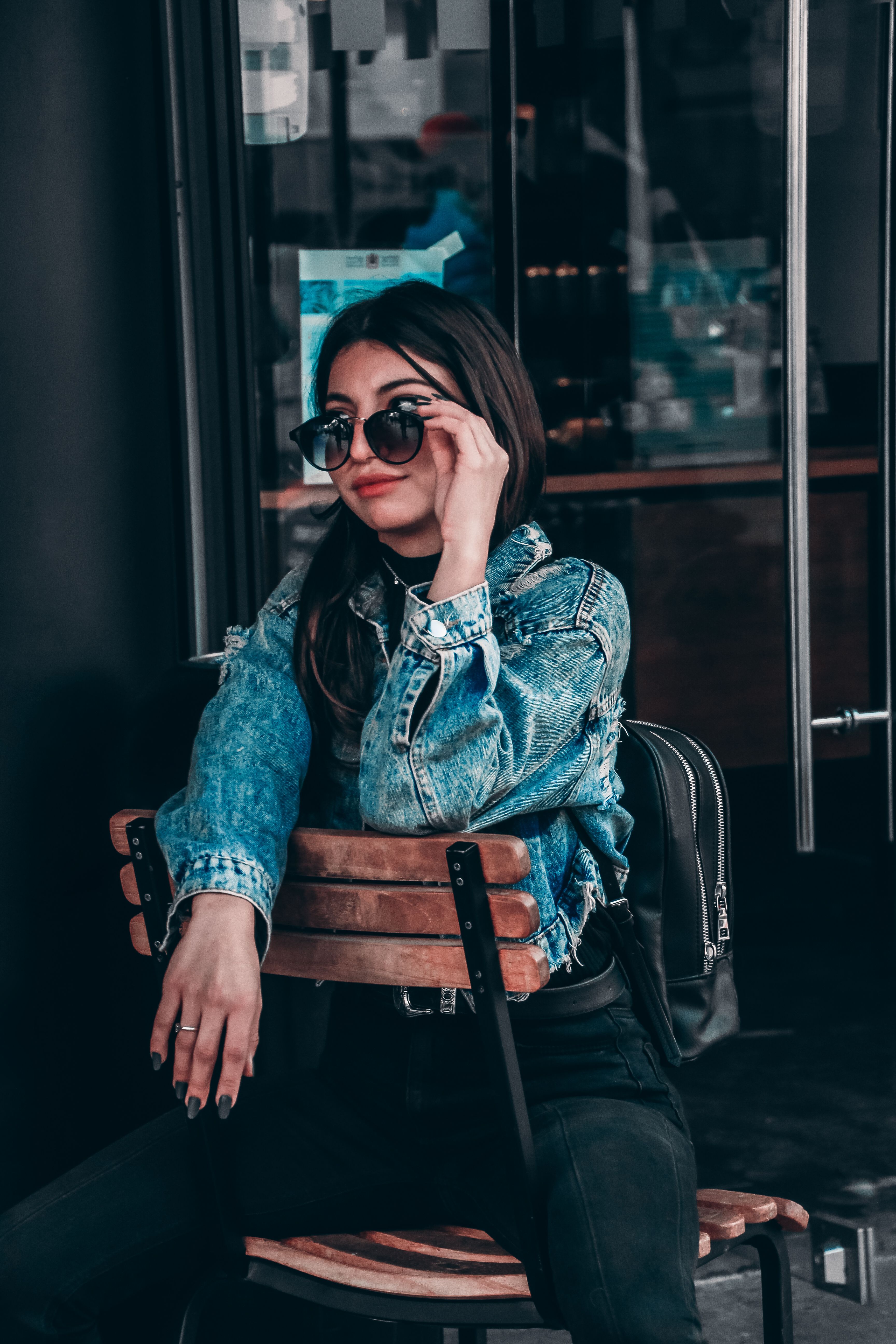 Woman in Blue Denim Jacket Sitting on Chair · Free Stock Photo