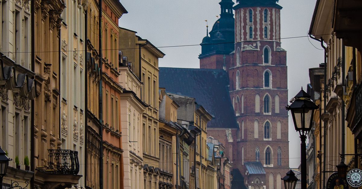A bustling street scene in Krakow's Old Town, featuring St. Mary's Basilica.