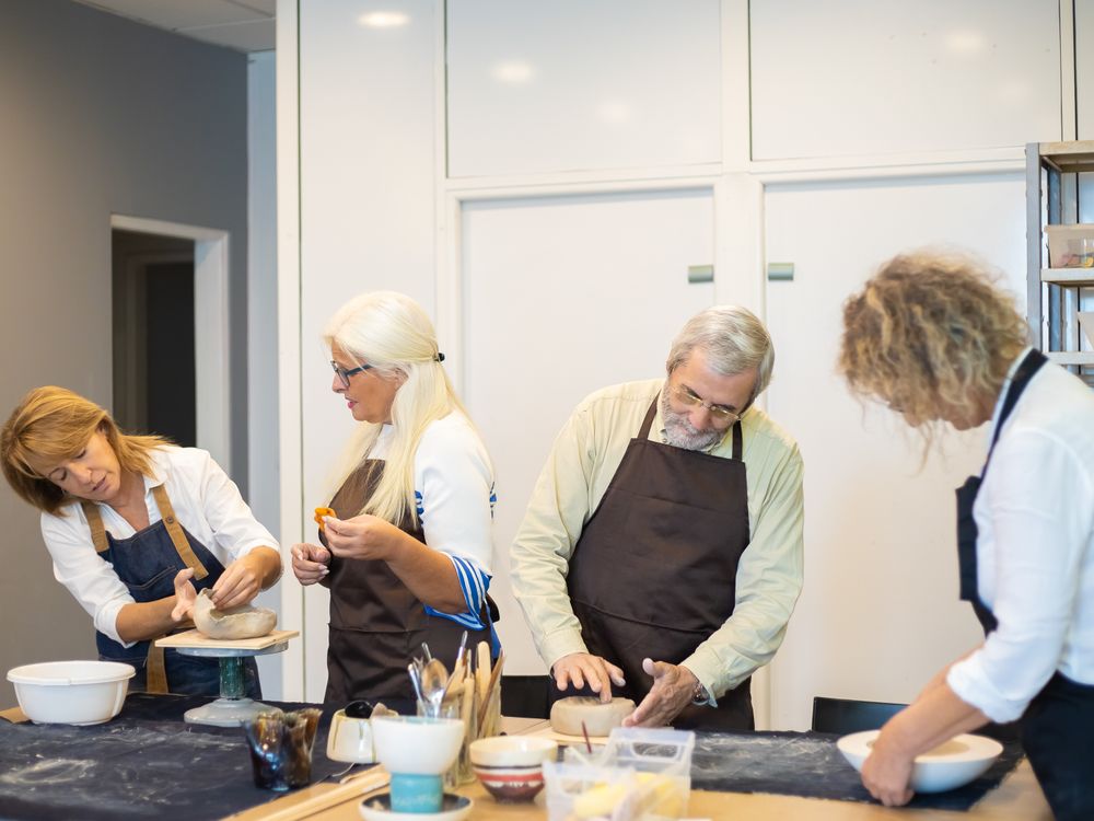 A small group shaping bowls at a pottery workshop