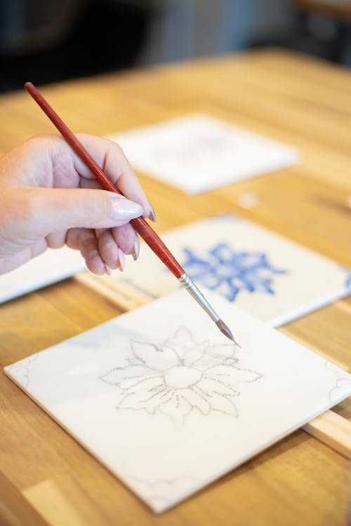 A Person Painting on the Ceramic Tile