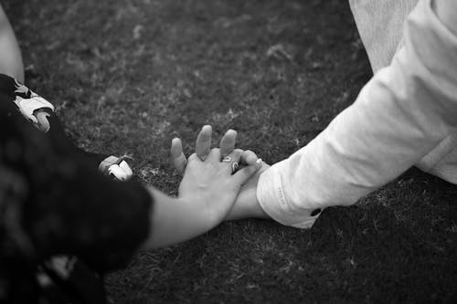 Grayscale Photo of 2 Person Holding Hands