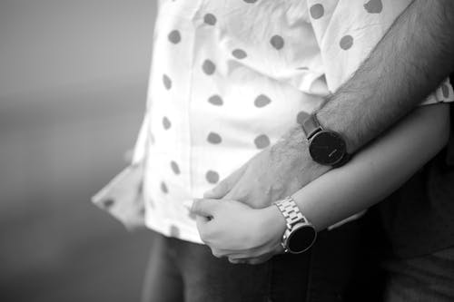 Grayscale Photo of a Couple Holding Hands