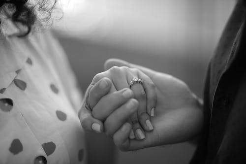 Grayscale Photo of Woman Holding Her Hand