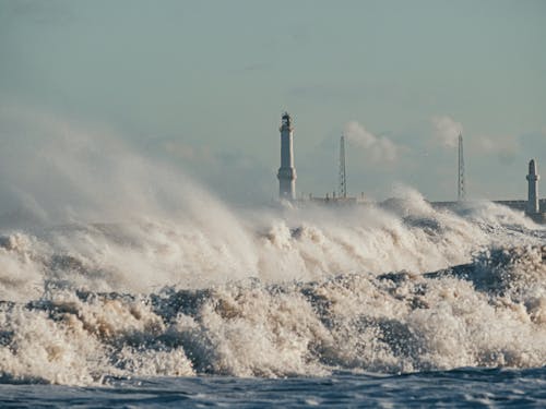 Waves Splashing near Shore with Lighthouse