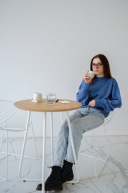 Relaxed woman with hot drink in armchair