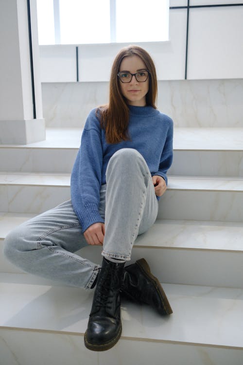 Woman in casual wear with crossed legs on stairs