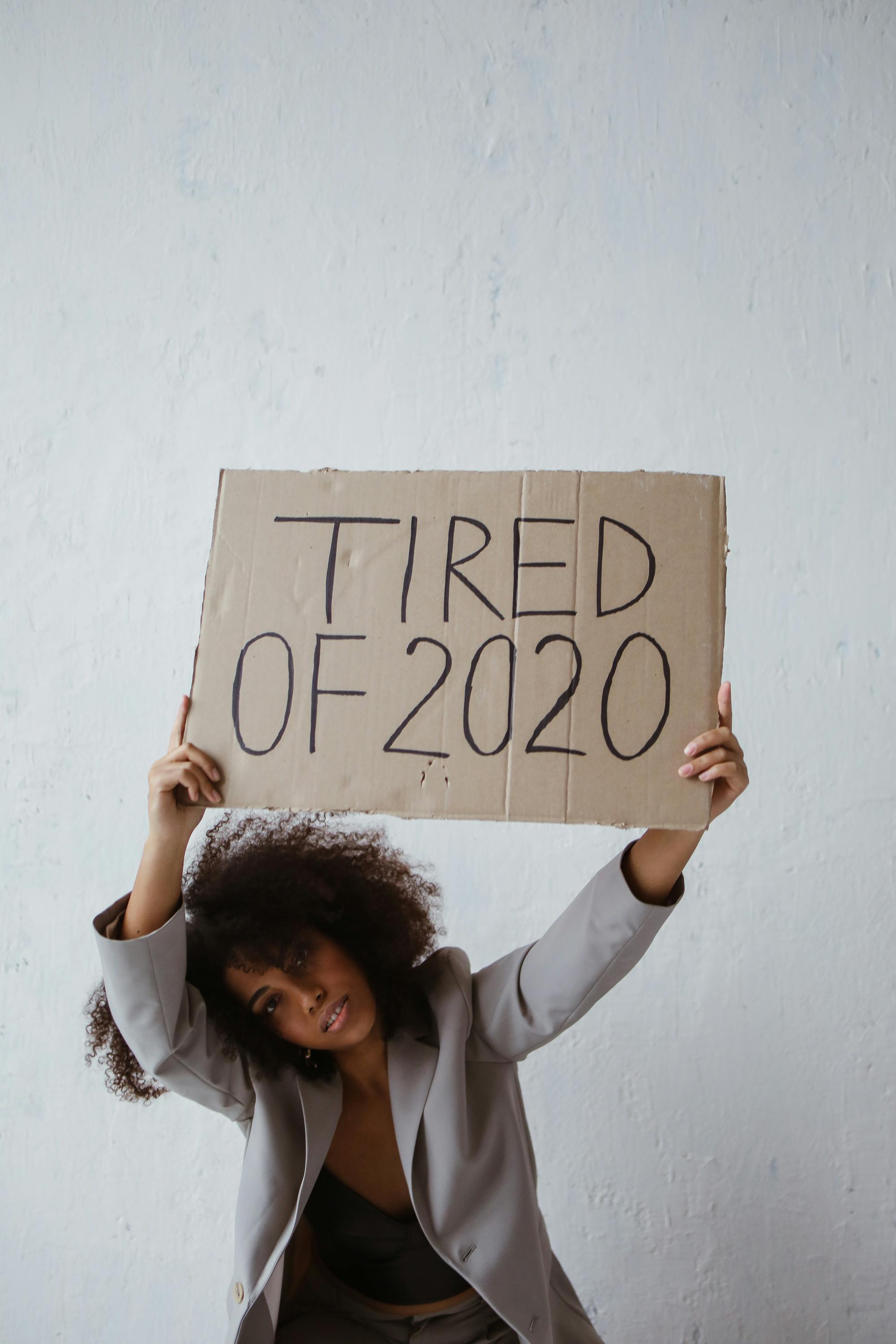 a woman holding a sign about burnout