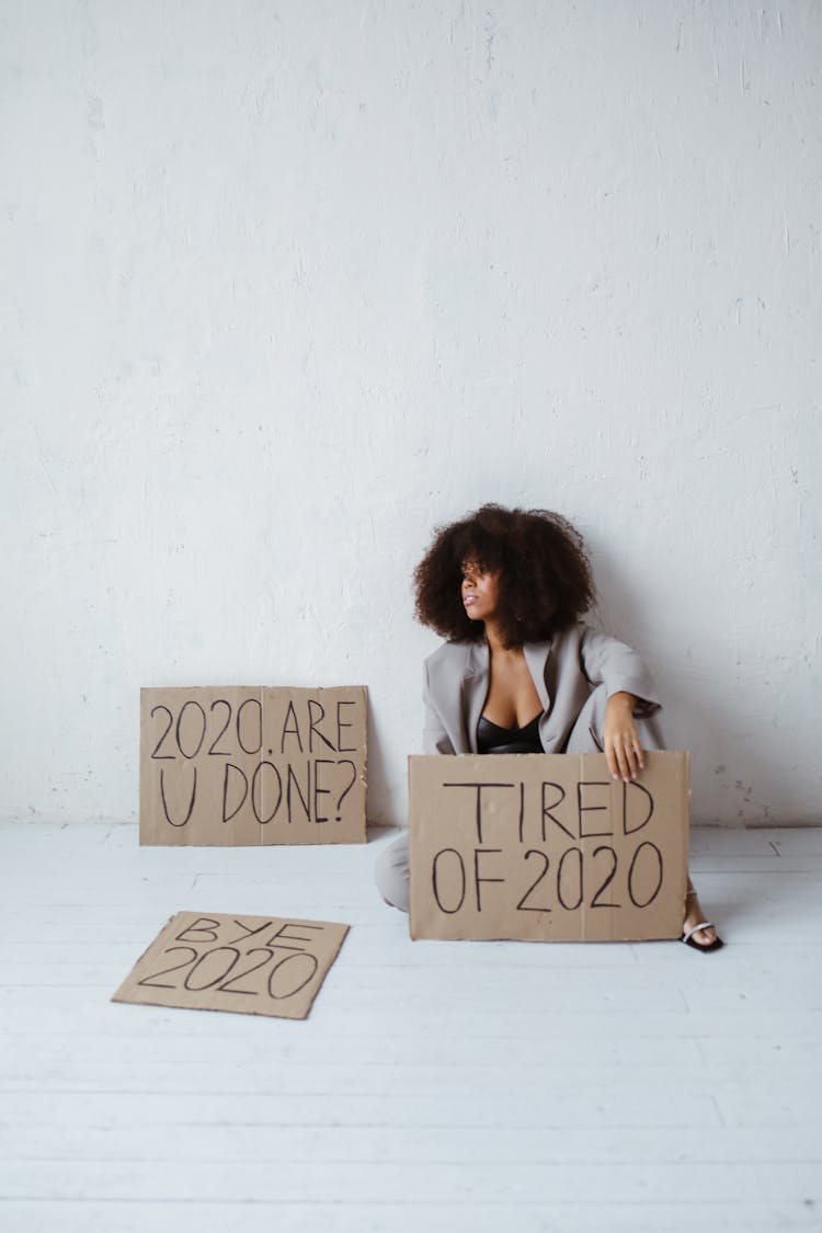 A Tired Woman Holding Signs About Burnout