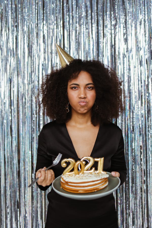 A Woman Celebrating the New Year While Eating a Cake