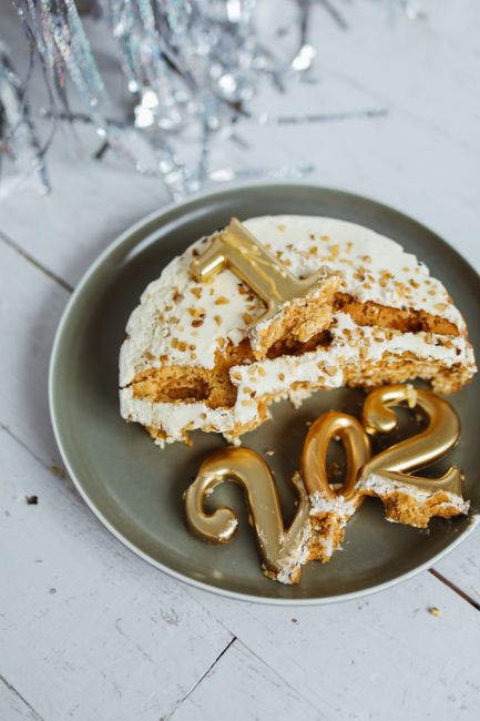 Celebrate the New Year with a delicious cake topped with broken golden 2023 candles for a festive touch.