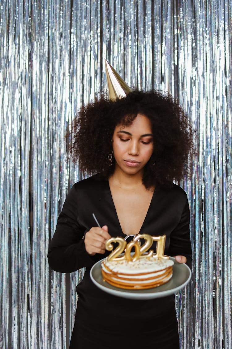 A Woman In Black Top Holding A Cake