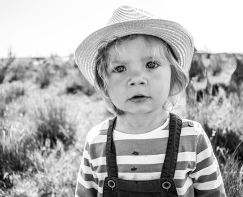Free Grayscale Photo of a Child Wearing a Hat  Stock Photo