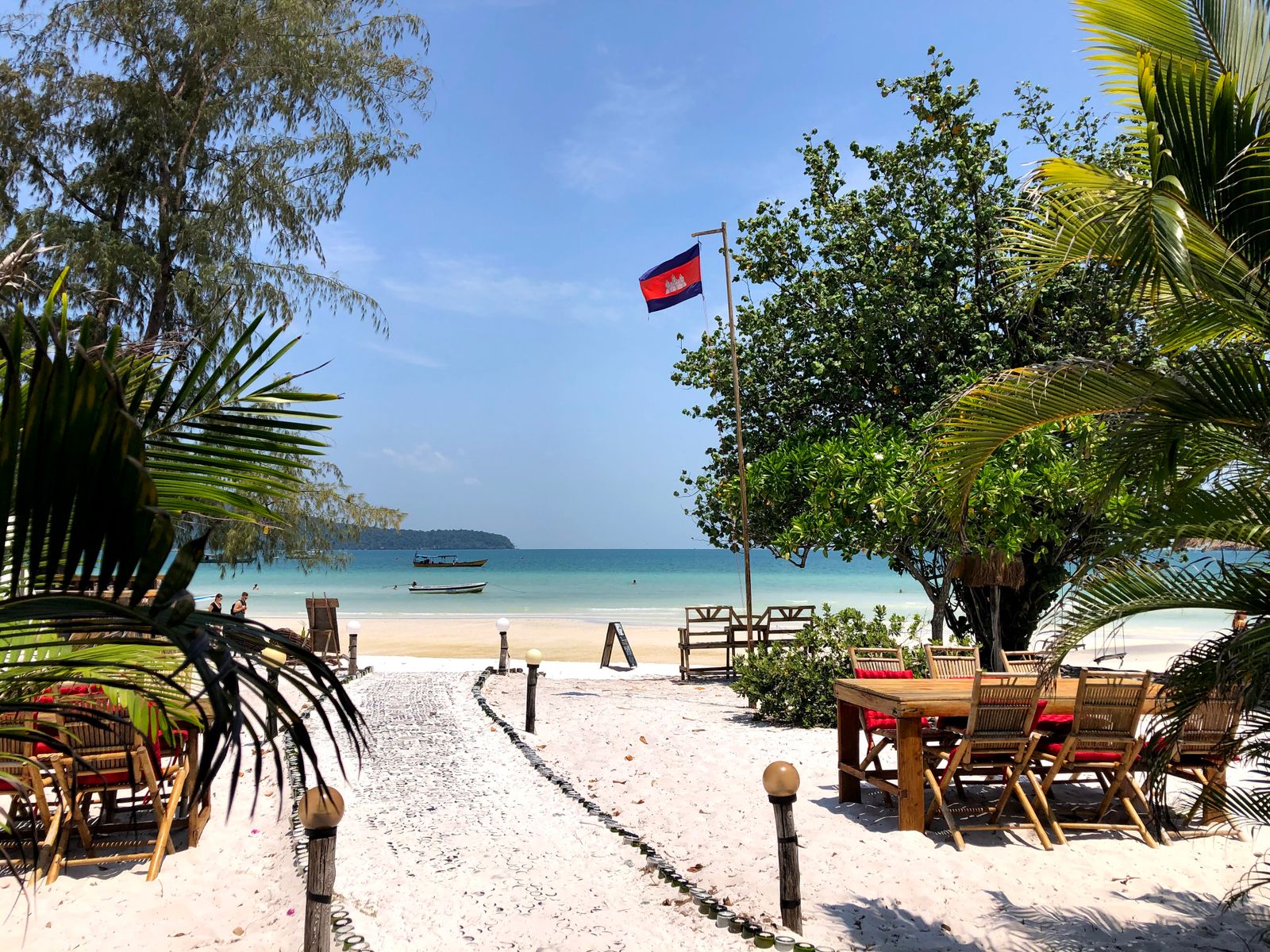 Beachfront dining area framed by palm trees overlooking the sea, Sihanoukville, Cambodia