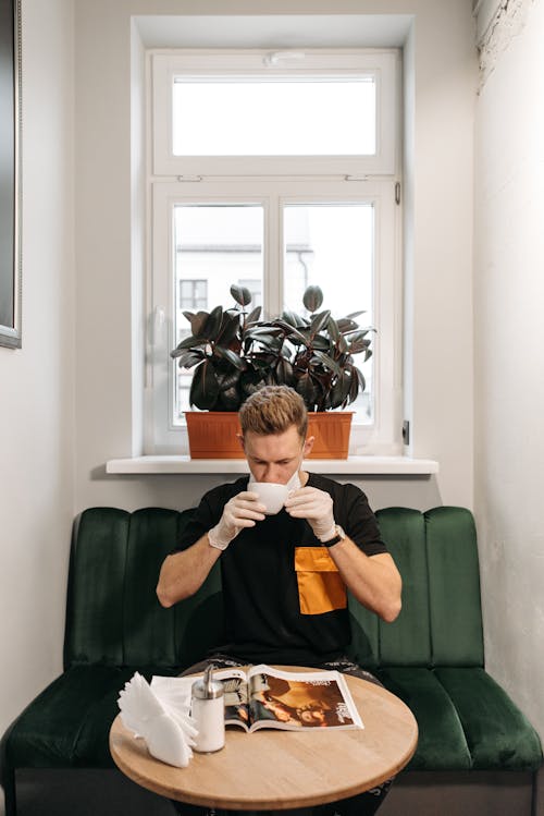 Free Man Drinking Coffee While Reading Magazine Stock Photo