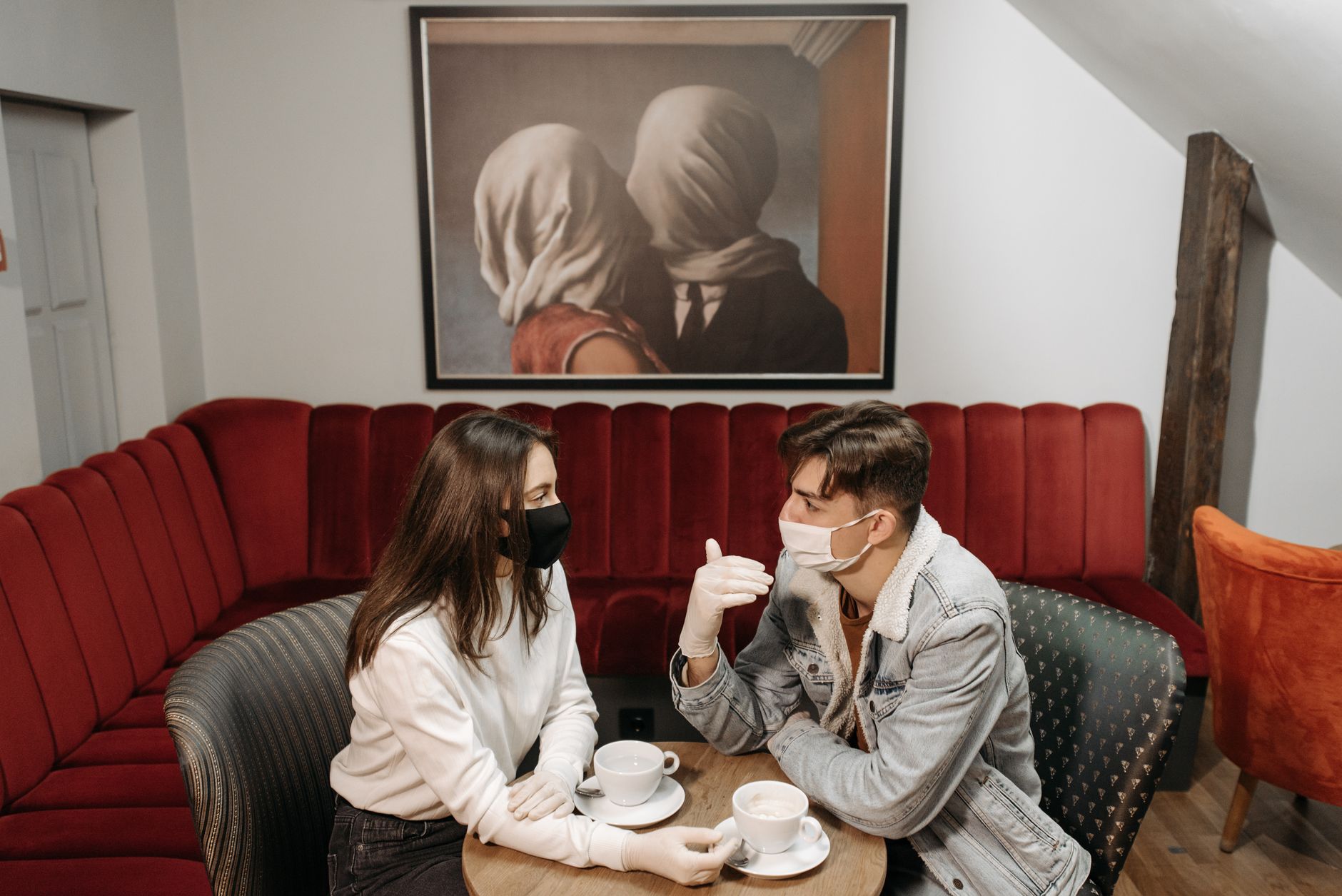 A couple sitting apart with coffee in a quiet café, the mood cooled