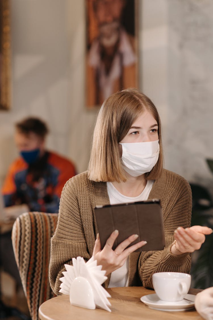 Woman In Brown Sweater Having Coffee