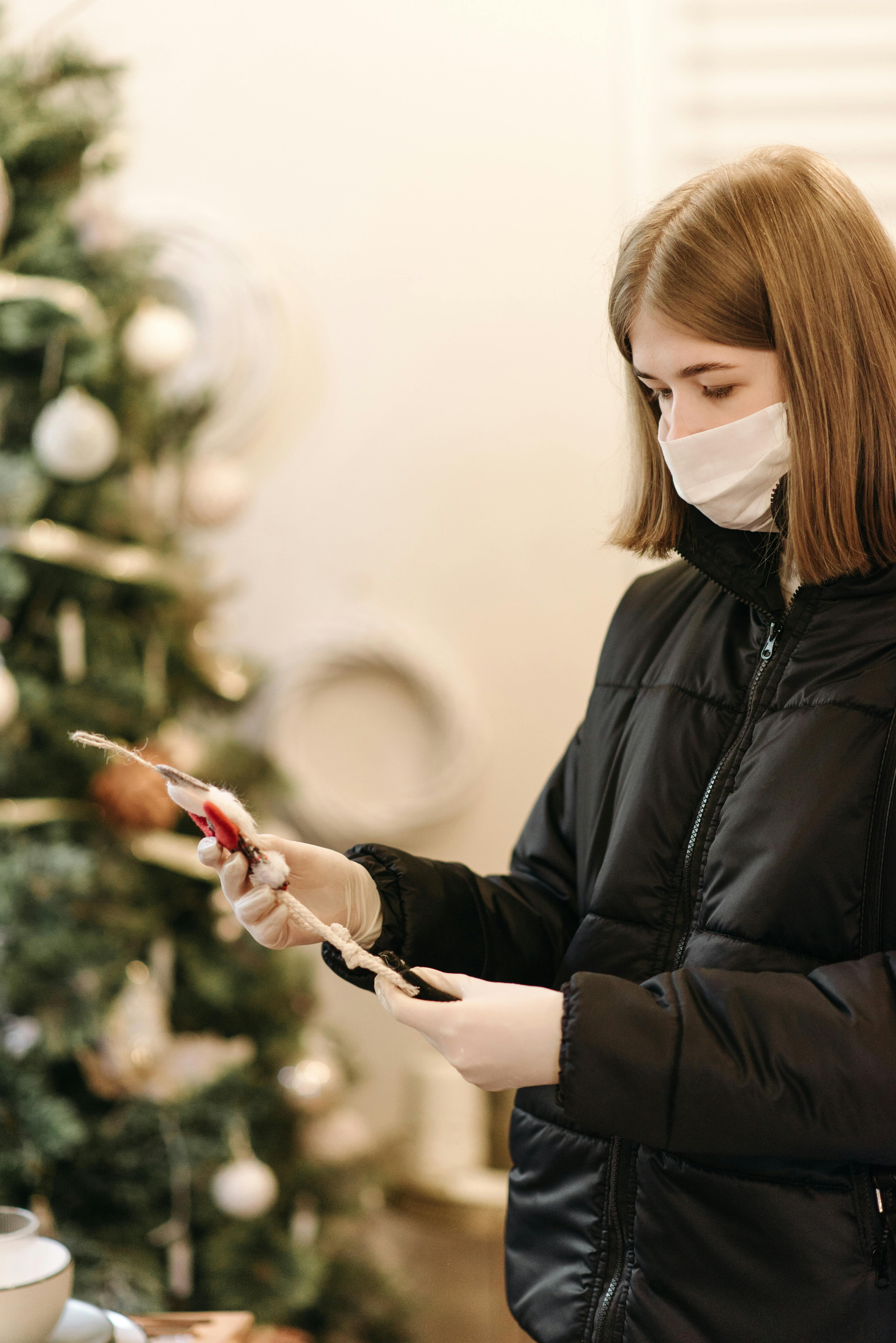 woman in black jacket holding a christmas ornament
