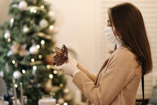 Woman wearing mask and gloves shopping indoors with Christmas decorations.