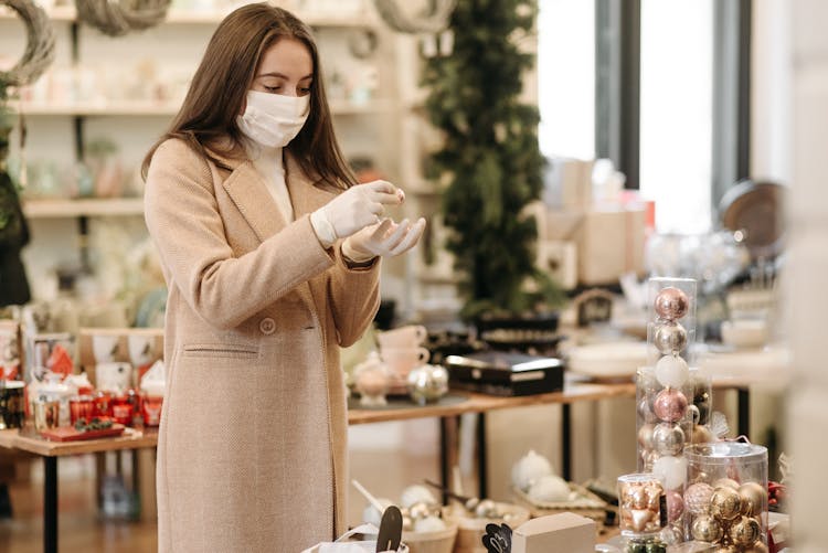 Woman In Brown Coat Holding A Christmas Decoration