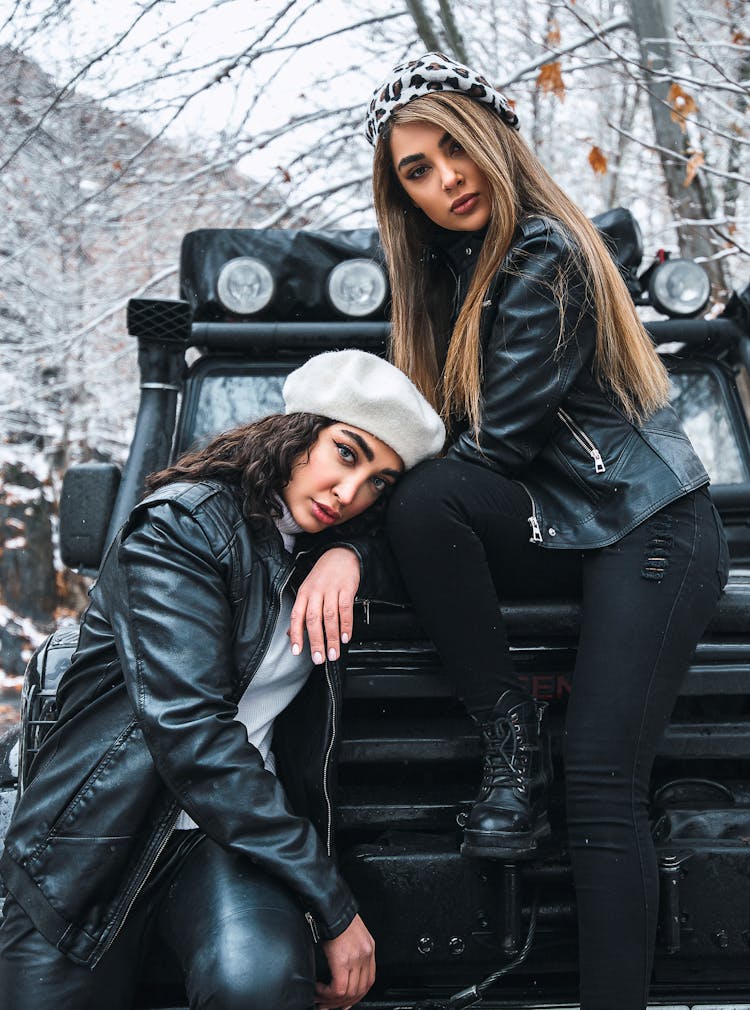 Women In Black Leather Jackets Sitting On A Car