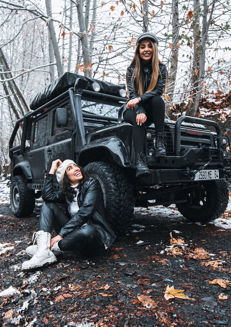 Women Sitting On A Black Vehicle