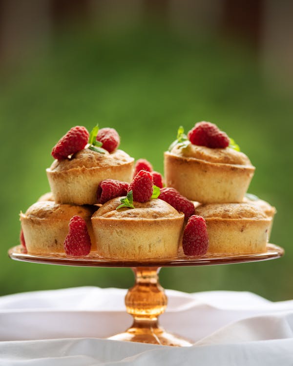 Delicious homemade cake decorated with raspberries and placed on table with white tablecloth