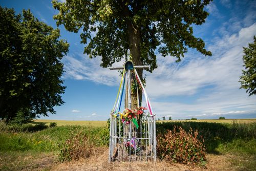 Free Scenic wayside shrine in Polish countryside, adorned with ribbons under blue sky. Stock Photo
