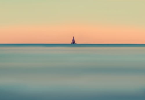 Free Silhouette of Sailboat on Sea during Sunset Stock Photo