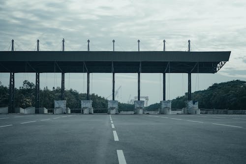Kostnadsfri bild av betongbeläggning, gråa moln, motorväg