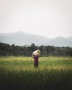 Woman carrying bag with cane in field