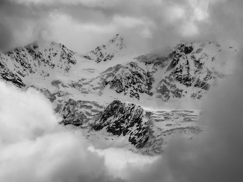 Snow Covered Mountain Under Cloudy Sky