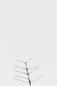 A simple television antenna stands out against a vast, empty sky, creating a minimalist look.