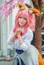 A Cute Cosplayer Standing Near the Tree