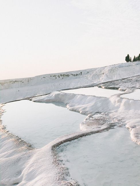Serene view of Pamukkale's white travertine terraces reflecting serene winter light.