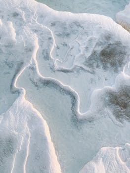 Abstract landscape of a frozen surface with intricate patterns and textures captured from above.