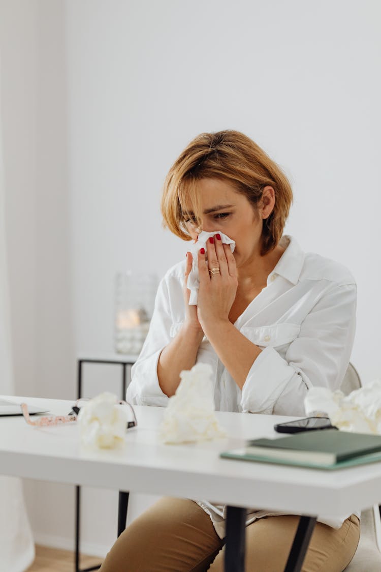 A Sad Woman Wiping Her Nose With Tissue