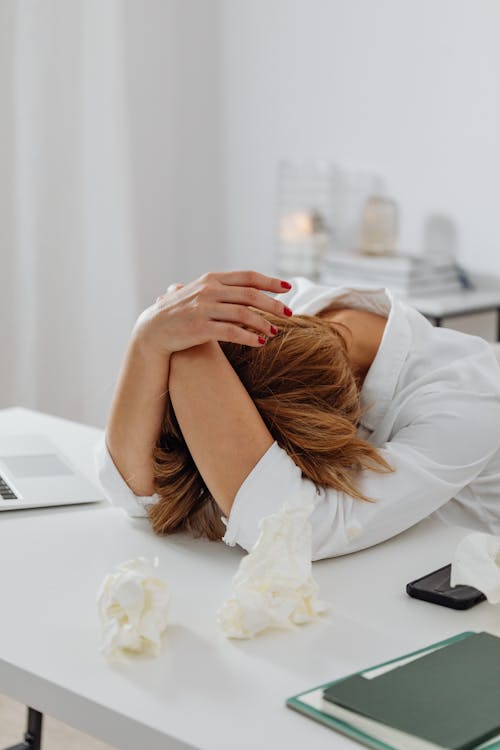 Free A Stressed Woman Leaning on White Table Stock Photo